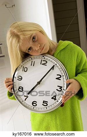 Stock Photograph - Portrait of a girl holding a clock. Fotosearch