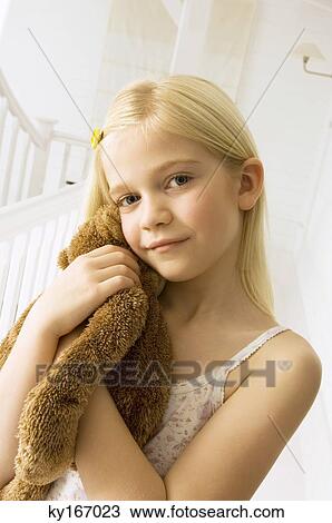 Stock Image - Portrait of a girl holding a teddy bear. Fotosearch