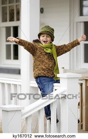 Portrait of a girl sitting on the railing of a house View Large Photo Image Stock Image - Portrait of a girl sitting on the railing of a house. Fotosearch