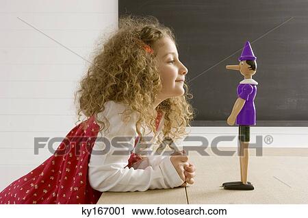 Side profile of a girl playing with a toy View Large Photo Image Stock Image - Side profile of a girl playing with a toy. Fotosearch