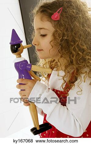 Side profile of a girl playing with a toy View Large Photo Image Stock Photo - Side profile of a girl playing with a toy. Fotosearch