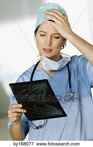Close-up of a female doctor examining an X-Ray report View Large Photo Image Stock Photo - Close-up of a female doctor examining an X-Ray report. Fotosearch