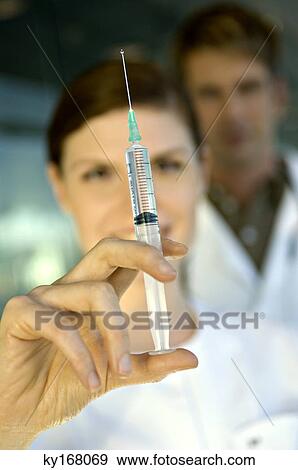 Close-up of a female doctor holding a syringe View Large Photo Image Stock Photo - Close-up of a female doctor holding a syringe. Fotosearch