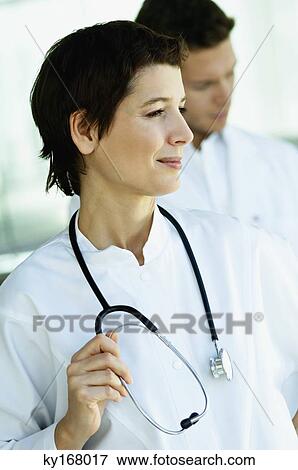 Close-up of a female doctor standing with a stethoscope around her neck View Large Photo Image Stock Photo - Close-up of a female doctor standing with a stethoscope around her neck. Fotosearch