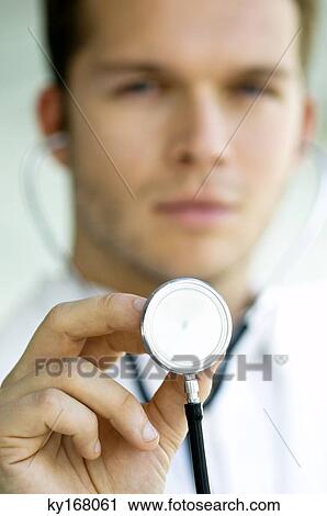 Close-up of a male doctor holding a stethoscope View Large Photo Image Stock Image - Close-up of a male doctor holding a stethoscope. Fotosearch