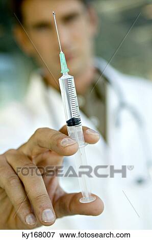 Close-up of a male doctor holding a syringe View Large Photo Image Stock Photo - Close-up of a male doctor holding a syringe. Fotosearch