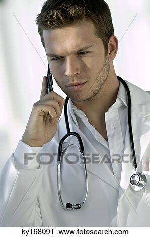 Close-up of a male doctor talking on a mobile phone View Large Photo Image Stock Image - Close-up of a male doctor talking on a mobile phone. Fotosearch