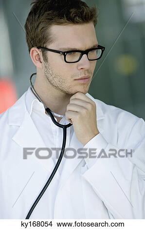Close-up of a male doctor thinking View Large Photo Image Picture - Close-up of a male doctor thinking. Fotosearch