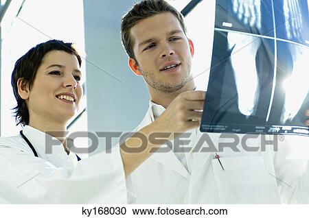 Close-up of two doctors examining an X-Ray report View Large Photo Image Stock Image - Close-up of two doctors examining an X-Ray report. Fotosearch