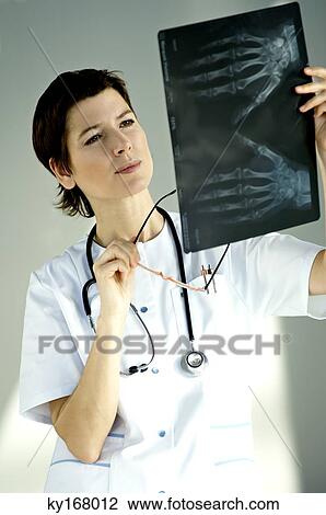 Female doctor examining an X-Ray report View Large Photo Image Stock Image - Female doctor examining an X-Ray report. Fotosearch