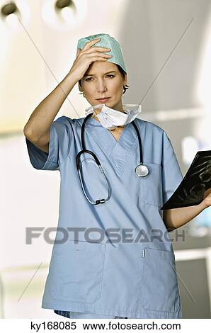Stock Photography - Female doctor holding an X-Ray report. Fotosearch