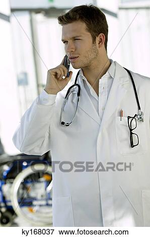 Male doctor talking on a mobile phone View Large Photo Image Stock Photo - Male doctor talking on a mobile phone. Fotosearch