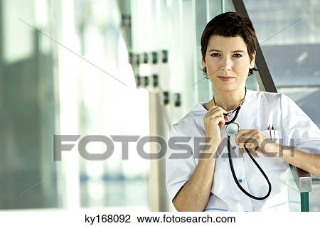 Portrait of a female doctor holding a stethoscope View Large Photo Image Stock Image - Portrait of a female doctor holding a stethoscope. Fotosearch