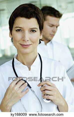 Stock Photo - Portrait of a female doctor standing with a stethoscope around her neck. Fotosearch