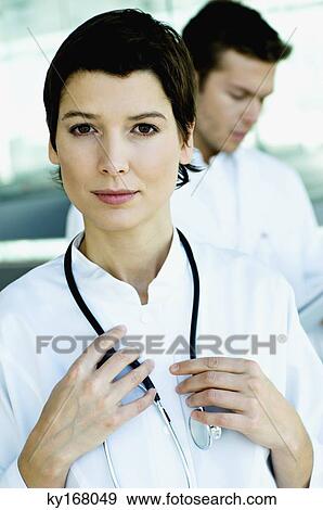 Stock Photo - Portrait of a female doctor standing with a stethoscope around her neck. Fotosearch