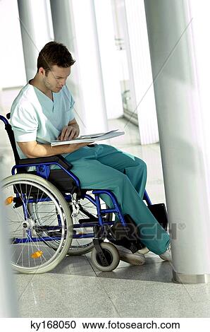 Side profile of a young man sitting in a wheelchair and reading a medical record View Large Photo Image Stock Image - Side profile of a young man sitting in a wheelchair and reading a medical record. Fotosearch