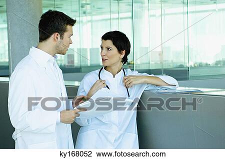 Two doctors discussing a medical record View Large Photo Image Stock Image - Two doctors discussing a medical record. Fotosearch