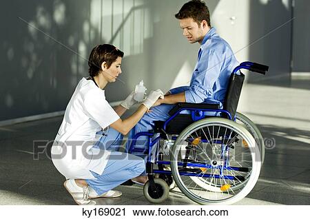 Stock Image - Female doctor applying medicine on a patient's hand. Fotosearch