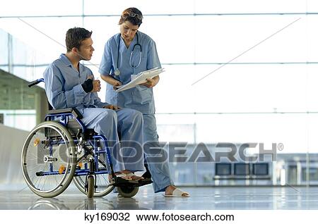 Stock Image - Female doctor showing a medical record to a patient. Fotosearch