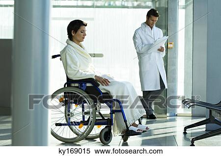 Female patient sitting in a wheelchair and a male doctor standing in the background View Large Photo Image Stock Photography - Female patient sitting in a wheelchair and a male doctor standing in the background. Fotosearch