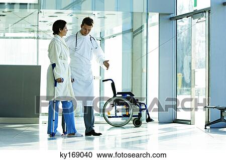Male doctor assisting a female patient in walking on crutches View Large Photo Image Stock Image - Male doctor assisting a female patient in walking on crutches. Fotosearch