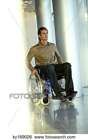 Mid adult man sitting in a wheelchair View Large Photo Image Stock Photograph - Mid adult man sitting in a wheelchair. Fotosearch