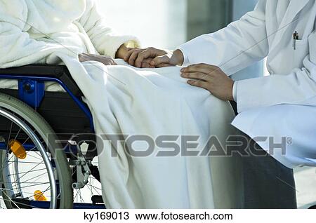 Mid section view of a male doctor consoling a disabled female patient View Large Photo Image Stock Image - Mid section view of a male doctor consoling a disabled female patient. Fotosearch