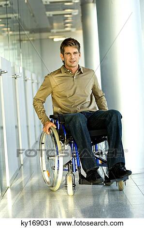 Stock Image - Portrait of a mid adult man sitting in a wheelchair. Fotosearch