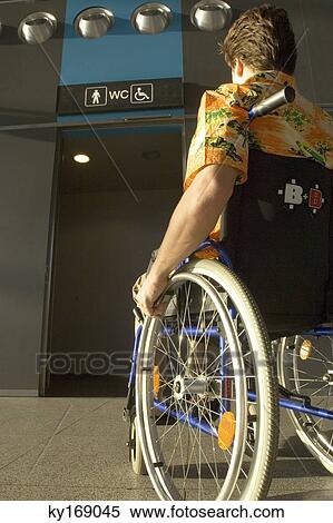 Rear view of a mid adult man sitting in a wheelchair View Large Photo Image Stock Photography - Rear view of a mid adult man sitting in a wheelchair. Fotosearch