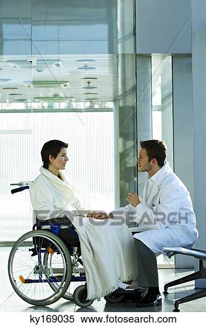 Side profile of a male doctor consoling a disabled female patient View Large Photo Image Stock Photography - Side profile of a male doctor consoling a disabled female patient. Fotosearch