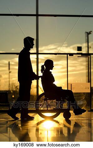 Silhouette of a man pushing a female patient sitting in a wheelchair View Large Photo Image Stock Photo - Silhouette of a man pushing a female patient sitting in a wheelchair. Fotosearch