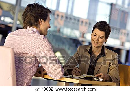 Stock Image - Businesswoman and a businessman in a meeting. Fotosearch