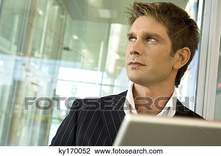 Close-up of a businessman looking away View Large Photo Image Stock Image - Close-up of a businessman looking away. Fotosearch