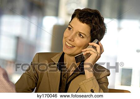 Stock Photograph - Close-up of a businesswoman talking on a mobile phone and smiling. Fotosearch