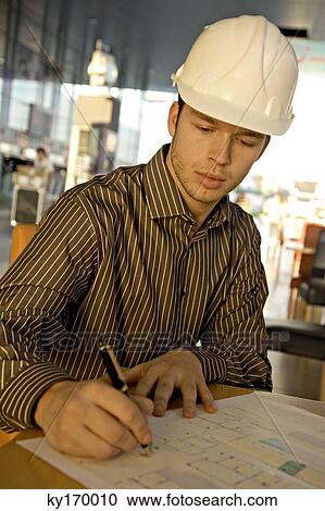 Male architect working on a blueprint View Large Photo Image Stock Image - Male architect working on a blueprint. Fotosearch