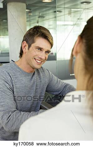 Mid adult man talking with a young woman View Large Photo Image Stock Photo - Mid adult man talking with a young woman. Fotosearch