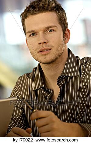 Portrait of a businessman holding a pen View Large Photo Image Stock Image - Portrait of a businessman holding a pen. Fotosearch