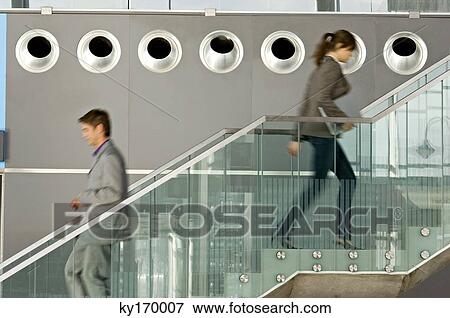 Side profile of a businessman and a businesswoman walking on a staircase View Large Photo Image Stock Photo - Side profile of a businessman and a businesswoman walking on a staircase. Fotosearch