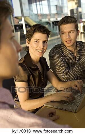 Two businessmen and a businesswoman sitting in a meeting View Large Photo Image Stock Image - Two businessmen and a businesswoman sitting in a meeting. Fotosearch