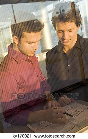 Two businessmen looking at a blueprint View Large Photo Image Stock Image - Two businessmen looking at a blueprint. Fotosearch
