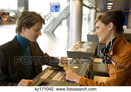 Businessman with a female check-in attendant at an airport check-in counter View Large Photo Image Stock Image - Businessman with a female check-in attendant at an airport check-in counter. Fotosearch