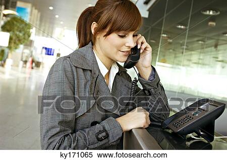 Close-up of a businesswoman talking on the telephone at an airport View Large Photo Image Stock Photography - Close-up of a businesswoman talking on the telephone at an airport. Fotosearch