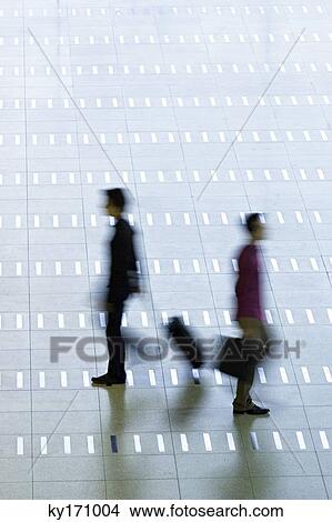 High angle view of two men walking at an airport lobby View Large Photo Image Picture - High angle view of two men walking at an airport lobby. Fotosearch