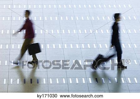 High angle view of two men walking at an airport lobby View Large Photo Image Stock Image - High angle view of two men walking at an airport lobby. Fotosearch