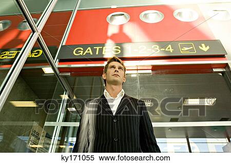Low angle view of a businessman standing at the gate at an airport View Large Photo Image Stock Photography - Low angle view of a businessman standing at the gate at an airport. Fotosearch