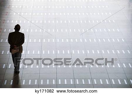 Man walking at airport, rear view View Large Photo Image Stock Image - Man walking at airport, rear view. Fotosearch
