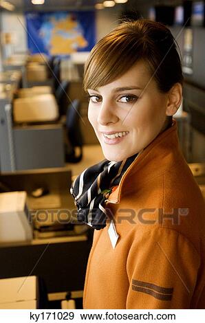 Portrait of a female airline check-in attendant smiling at an airport check-in counter View Large Photo Image Stock Photo - Portrait of a female airline check-in attendant smiling at an airport check-in counter. Fotosearch