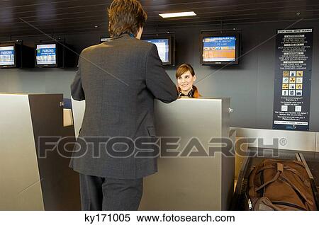Rear view of a businessman standing at an airport check-in counter View Large Photo Image Stock Photography - Rear view of a businessman standing at an airport check-in counter. Fotosearch