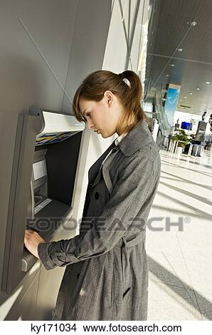 Side profile of a businesswoman using an ATM View Large Photo Image Picture - Side profile of a businesswoman using an ATM. Fotosearch