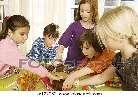 Children picking up pieces of a cake View Large Photo Image Stock Image - Children picking up pieces of a cake. Fotosearch